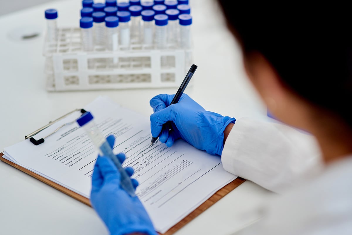 Scientist documenting assay specifications under CLIA certification.